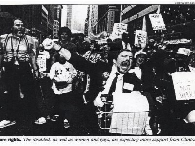 A black and white news photo of a passionate crowd of disability rights protesters shouting and raising their fists.