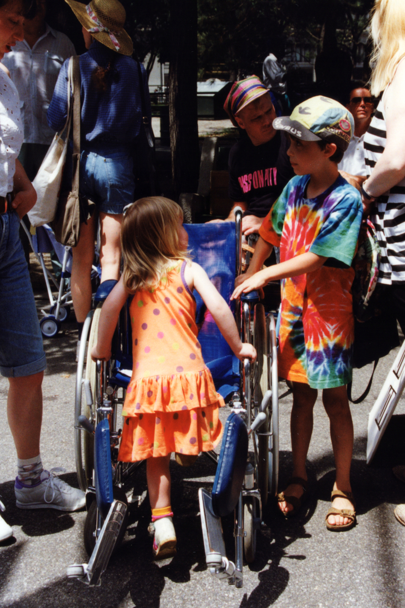A young girl climbs into a rented wheelchair
