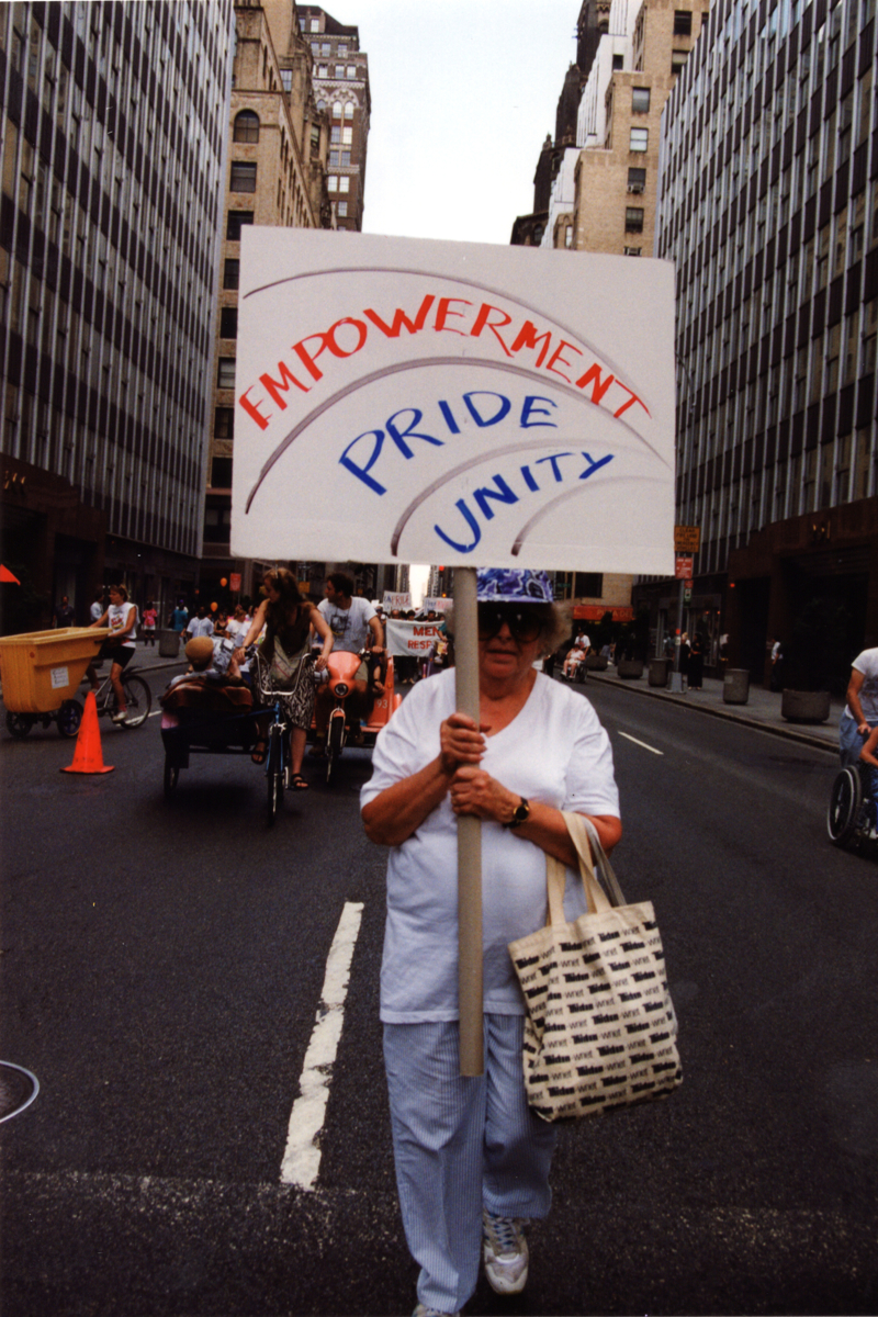 A marcher walks down a New York City street holding a sign