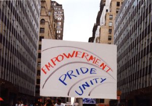 A marcher walks down a New York City street holding a sign